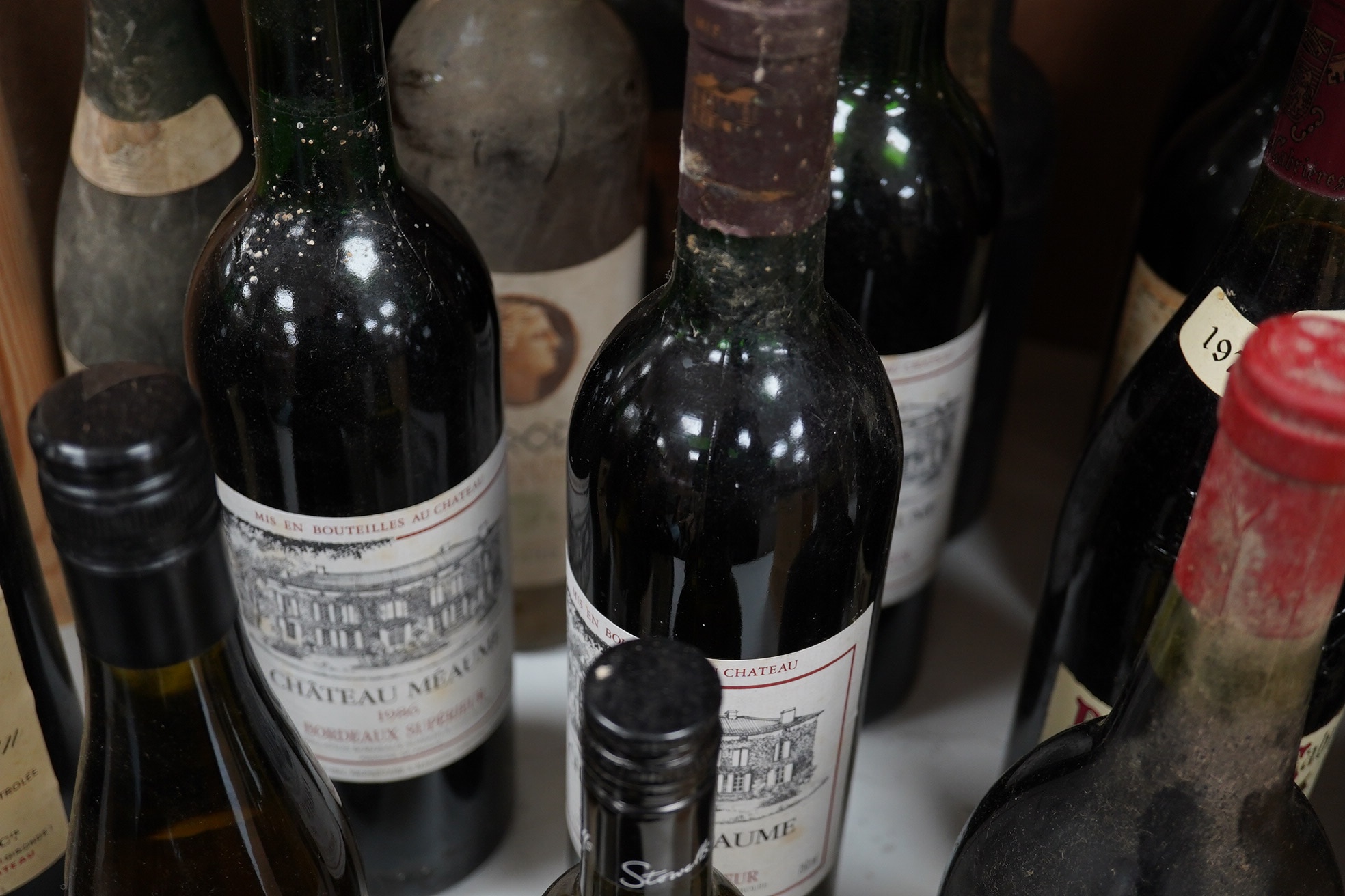 Twenty-five bottles and half bottles of wine, including; four bottles of Chateau Meaume 1986 Bordeaux Superior, a bottle of 1982 Chateau Montbrun Margaux, a Harveys Bourgogne Aligote 1970, etc. Condition - poor to fair